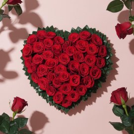 Heart icon made of red roses the heart is surrounded by green leaves
